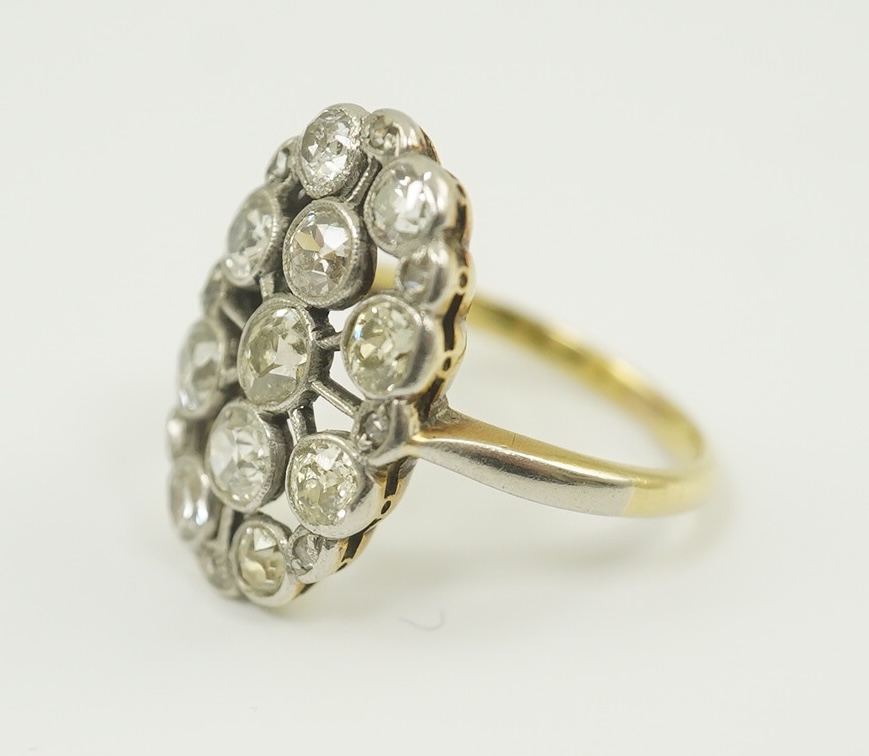 A 1940's 18ct gold, platinum and millegrain set diamond oval cluster ring